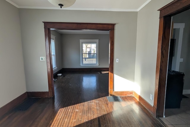 unfurnished room with visible vents, crown molding, baseboards, and hardwood / wood-style floors