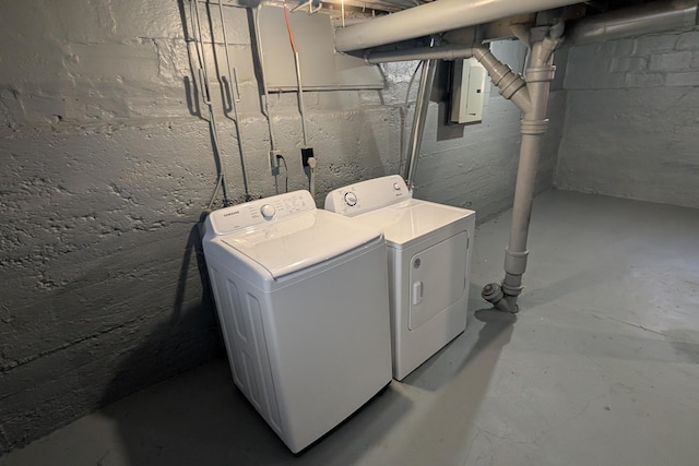 clothes washing area featuring electric panel, laundry area, and washing machine and dryer