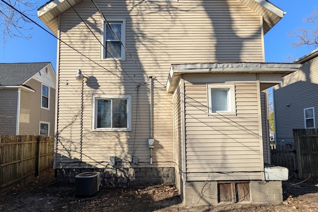 back of house featuring central AC unit and fence