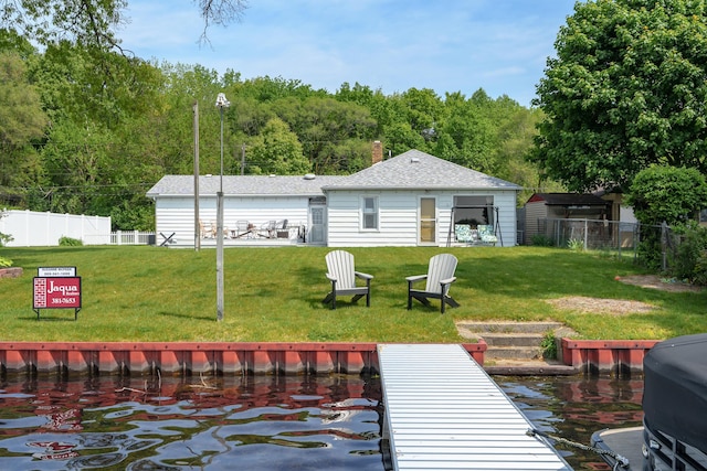 back of property with a lawn, a chimney, and fence