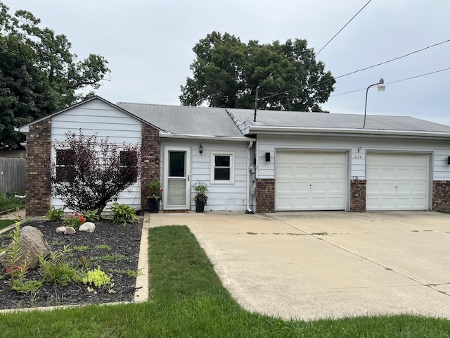 ranch-style house with brick siding, an attached garage, and concrete driveway