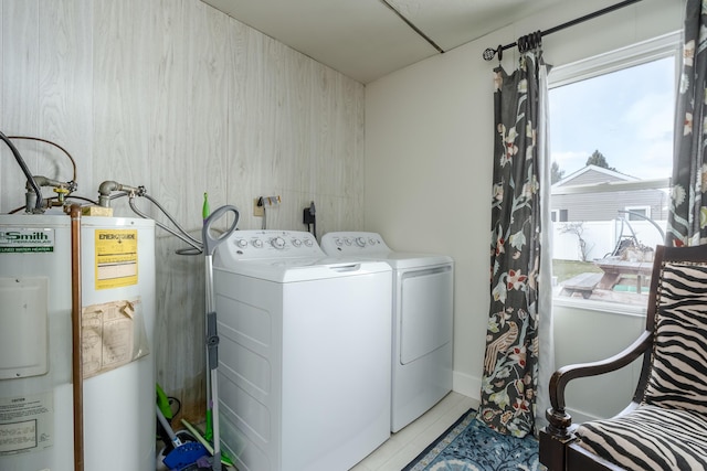 washroom featuring washing machine and clothes dryer, laundry area, gas water heater, and light tile patterned floors