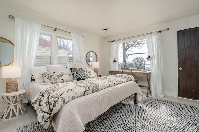 bedroom with multiple windows, wood finished floors, and visible vents