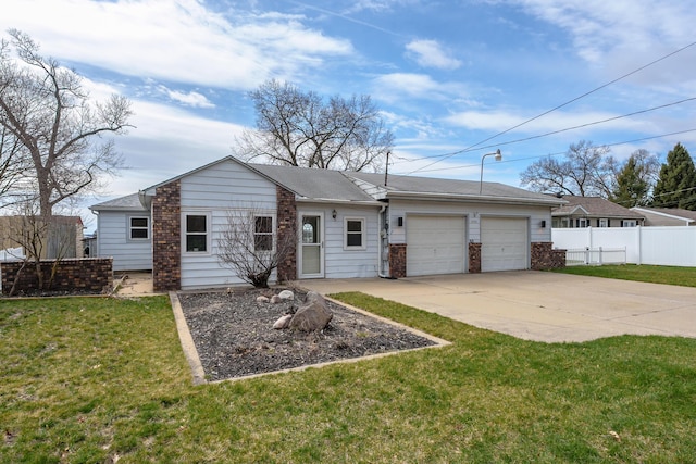 back of property featuring a yard, concrete driveway, an attached garage, and fence