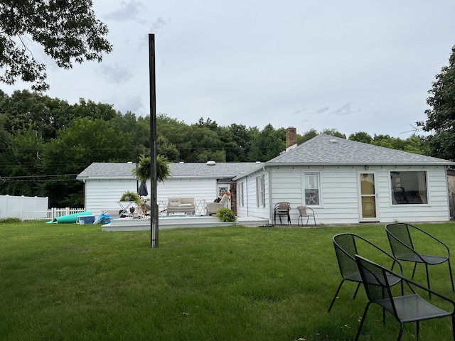 rear view of property with a patio, fence, a yard, a shingled roof, and a chimney