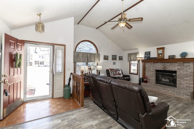 living room with a fireplace, parquet flooring, a ceiling fan, and high vaulted ceiling