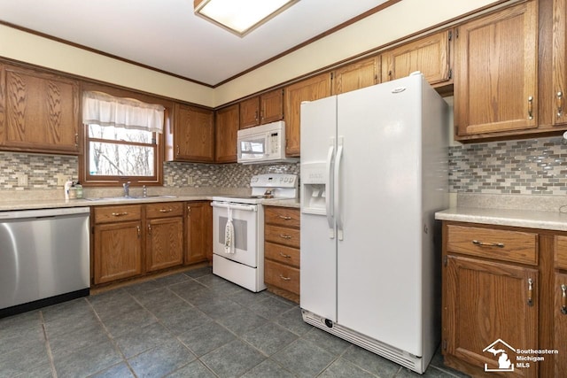 kitchen featuring white appliances, brown cabinets, backsplash, and a sink