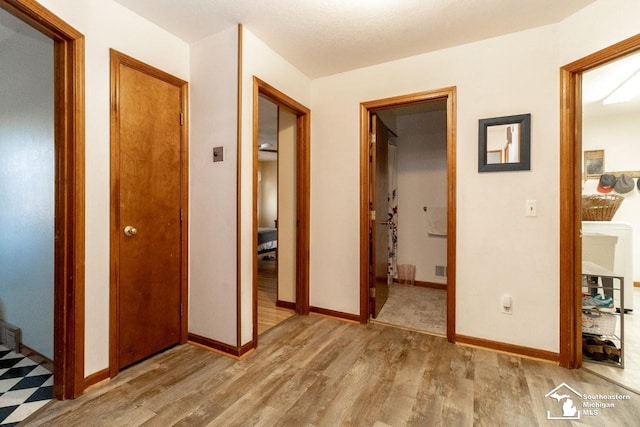 corridor with baseboards and wood finished floors