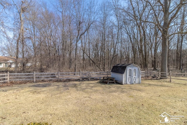 view of yard with a storage shed, an outdoor structure, and fence