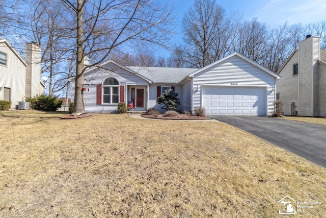 single story home featuring driveway, roof with shingles, an attached garage, central AC, and a front lawn