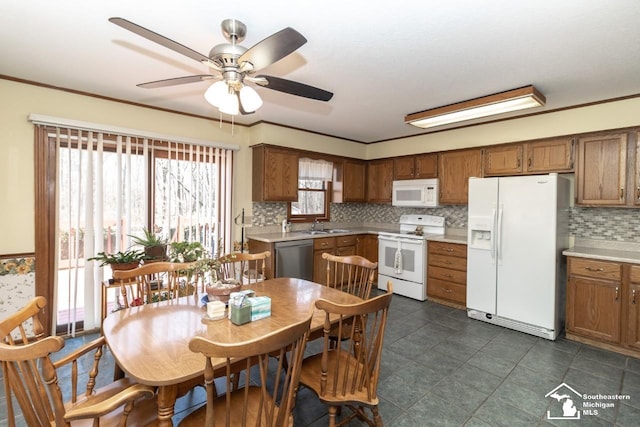 kitchen with brown cabinetry, white appliances, and light countertops