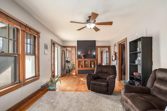 living room with visible vents, ceiling fan, and wood finished floors