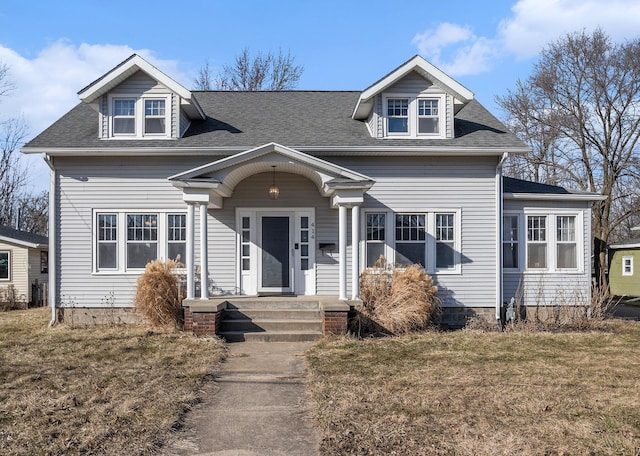 view of front of property with a front lawn and roof with shingles