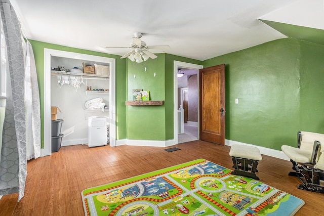 game room with visible vents, built in features, wood finished floors, baseboards, and ceiling fan