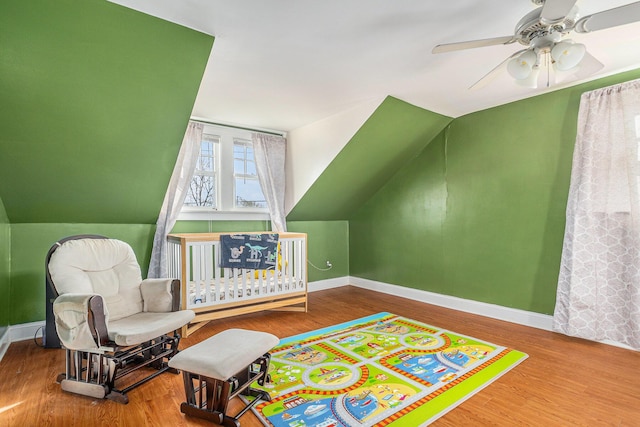 living area with lofted ceiling, wood finished floors, baseboards, and ceiling fan