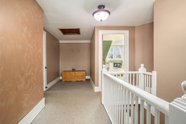 corridor with carpet flooring, an upstairs landing, and baseboards