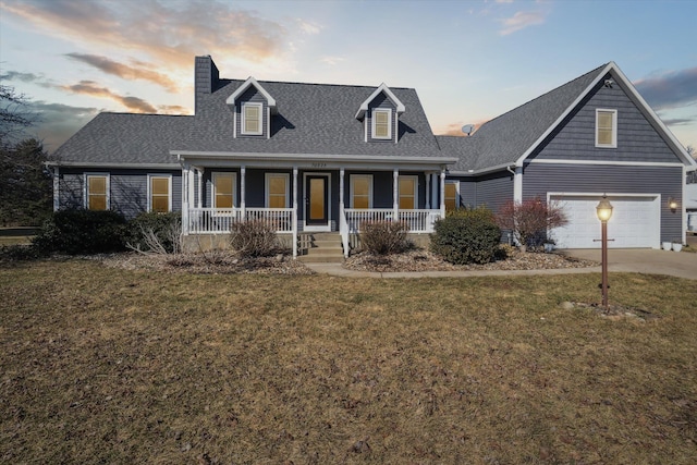 cape cod house featuring driveway, a porch, a yard, roof with shingles, and an attached garage