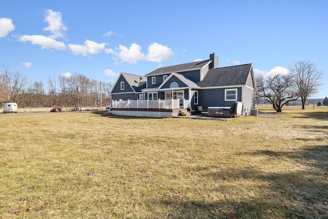 rear view of house with a deck, a lawn, central AC, and a chimney