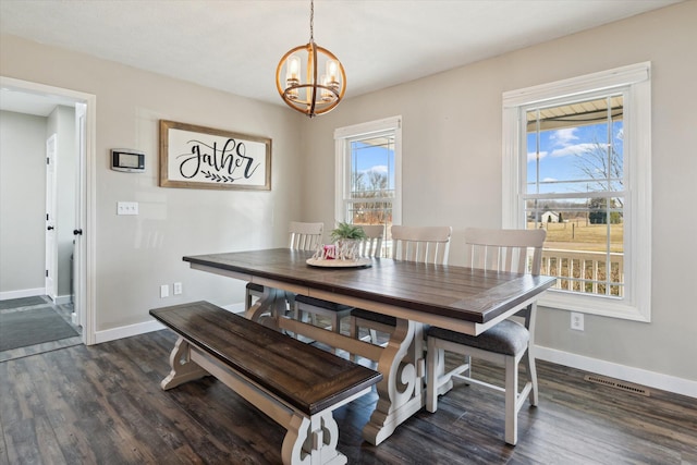 dining space featuring visible vents, a healthy amount of sunlight, a chandelier, and dark wood finished floors