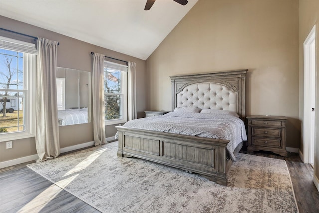 bedroom featuring ceiling fan, baseboards, wood finished floors, and vaulted ceiling