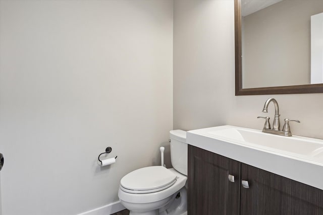 bathroom featuring vanity, toilet, and baseboards