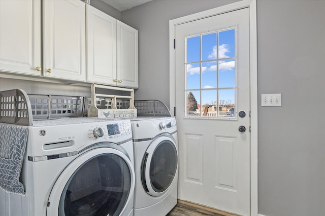 washroom with separate washer and dryer, wood finished floors, and cabinet space