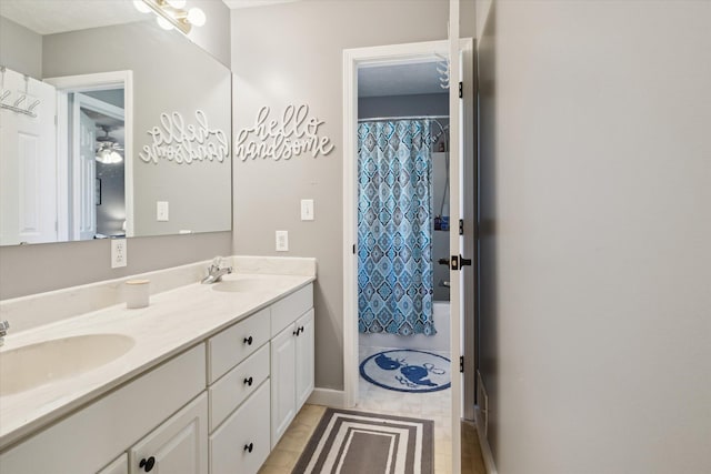 bathroom featuring double vanity, a shower with curtain, and a sink