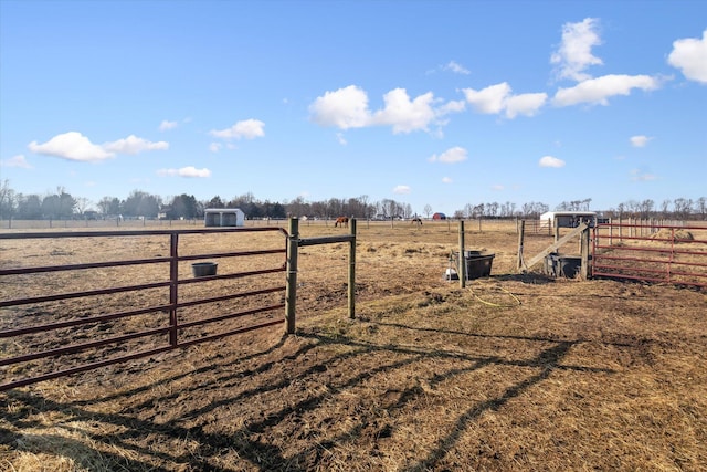 view of yard featuring a rural view, fence, and a gate