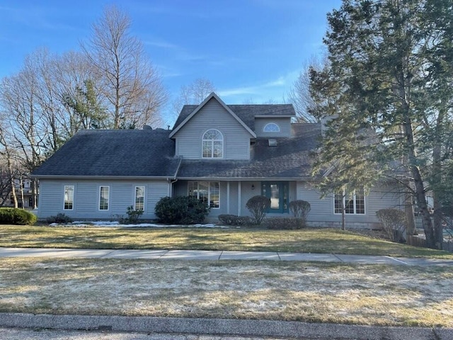 view of front of property featuring a front yard and a shingled roof