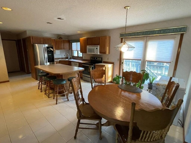 dining area featuring light tile patterned floors, recessed lighting, and a textured ceiling