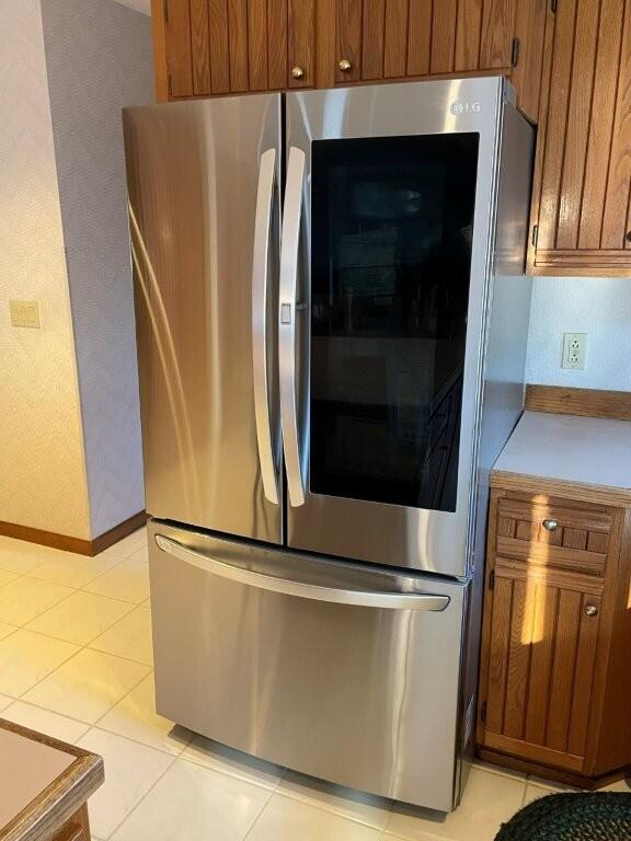 details featuring brown cabinetry, smart refrigerator, and light countertops