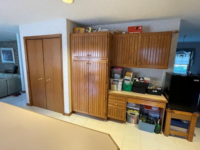 kitchen with brown cabinetry and a textured ceiling