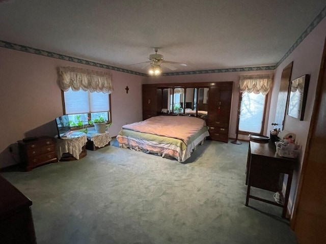 carpeted bedroom with multiple windows and ceiling fan