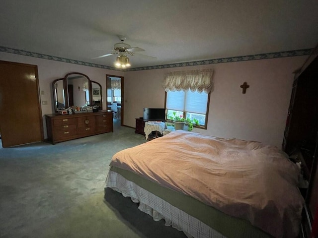 bedroom featuring light carpet and a ceiling fan