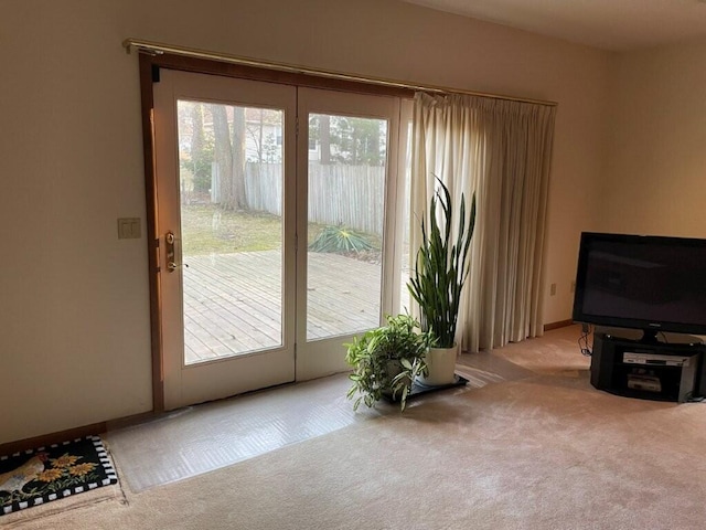 doorway with a wealth of natural light and carpet floors