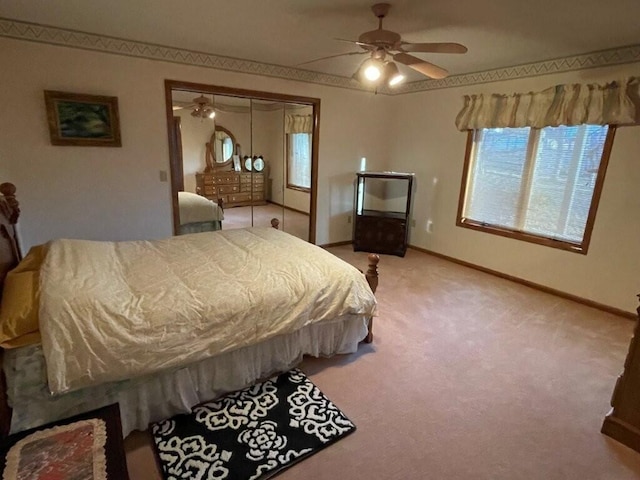 bedroom featuring a ceiling fan, baseboards, and light carpet