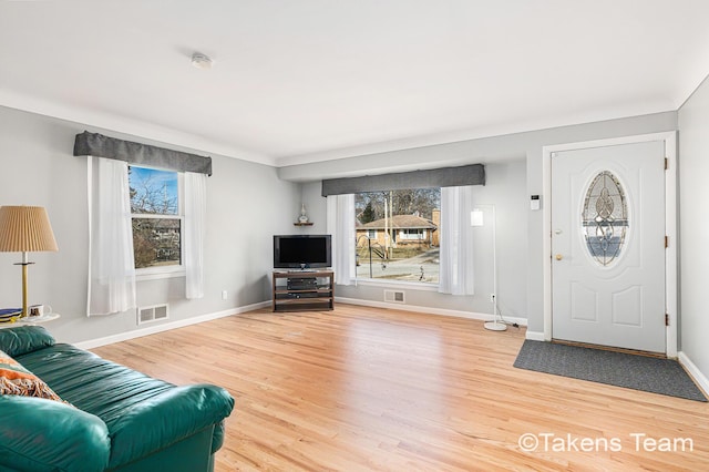 foyer featuring visible vents, baseboards, and wood finished floors