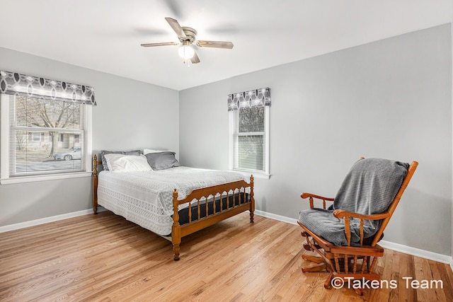 bedroom with light wood-type flooring, multiple windows, and baseboards