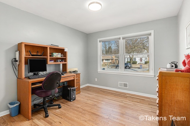 home office with light wood-type flooring, visible vents, and baseboards