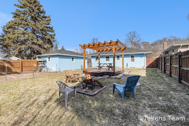 rear view of house featuring a lawn, a fire pit, a pergola, and a wooden deck