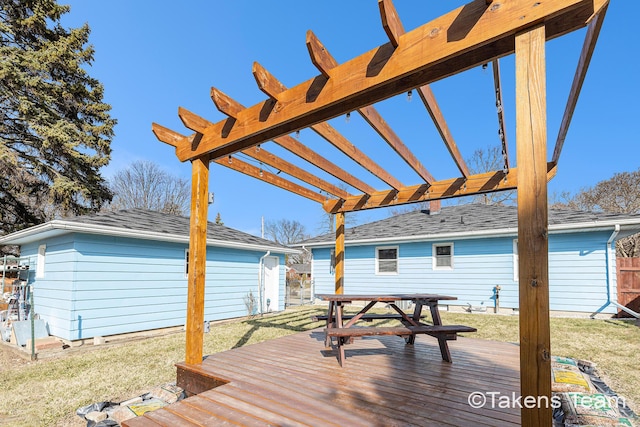 wooden deck featuring an outbuilding, fence, a yard, outdoor dining area, and a pergola