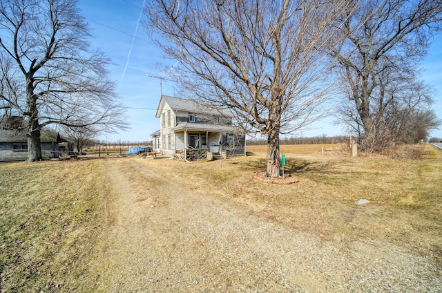 view of front of home featuring a front yard and dirt driveway