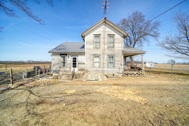 back of property with metal roof and fence