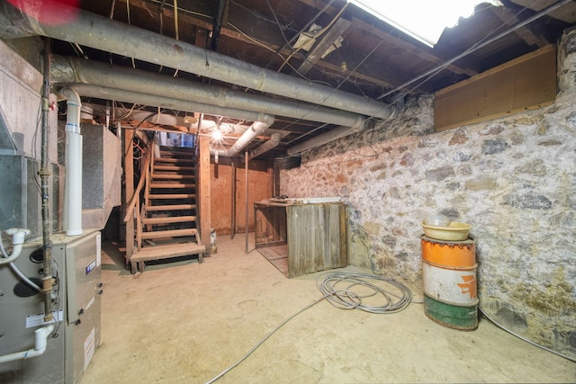 unfinished basement featuring stairs and heating unit