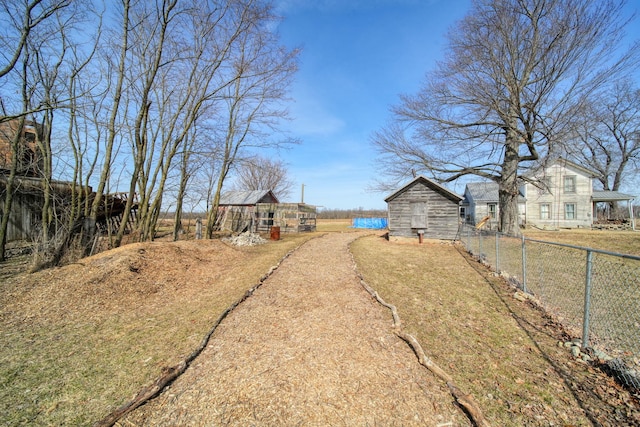 view of yard featuring an outbuilding and fence