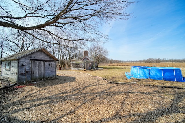 view of yard with a storage shed, an outbuilding, and an outdoor pool