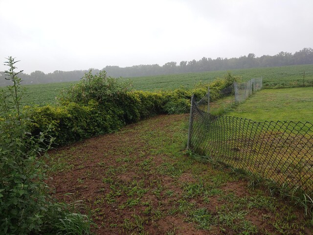 view of yard featuring a rural view and fence