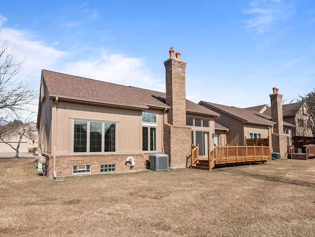 rear view of house with cooling unit, a deck, a chimney, and a shingled roof