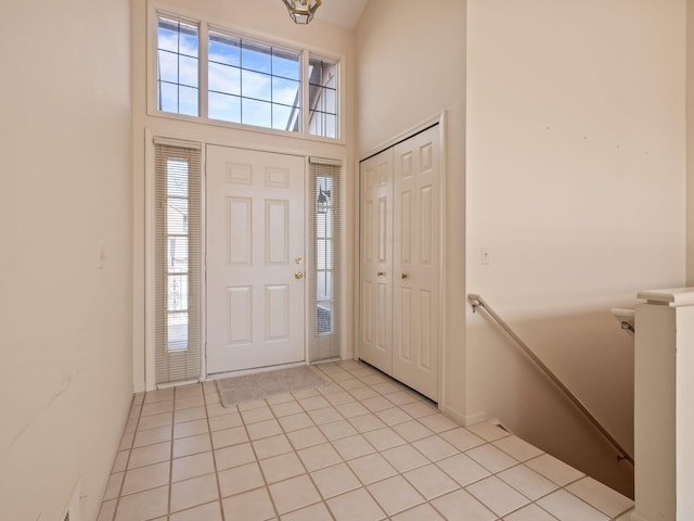 foyer with a high ceiling and light tile patterned flooring