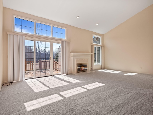 unfurnished living room featuring a fireplace with flush hearth, recessed lighting, high vaulted ceiling, and carpet floors